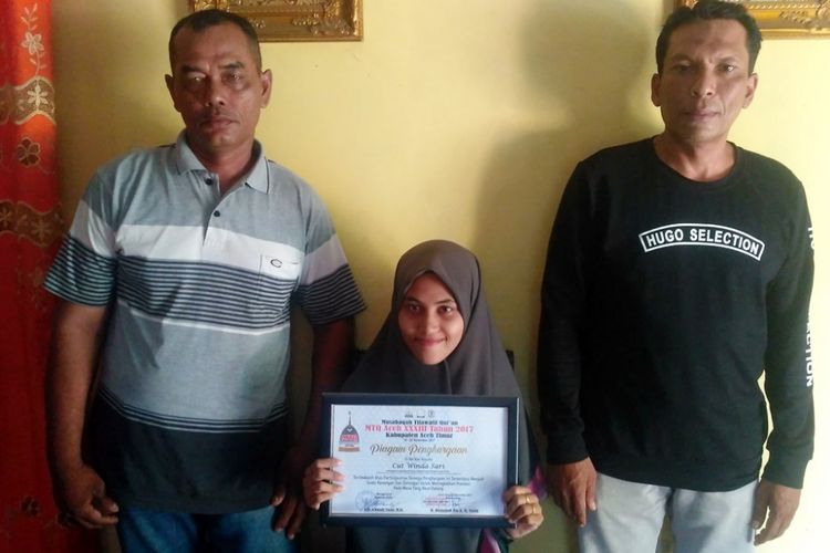 Cut Winda Sari (18), ditemani kelurganya memperlihatkan piagam penghargaan penghapal Quran di rumahnya warga Desa Ujong Blang, Kecamatan Sakti, Kota Lhokseumawe, Selasa (5/3/2019)