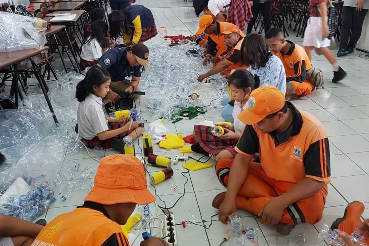 Siswa SD Tarakanita dibantu pasukan orange pada proses pembuatan bahan dasar pohon natal.