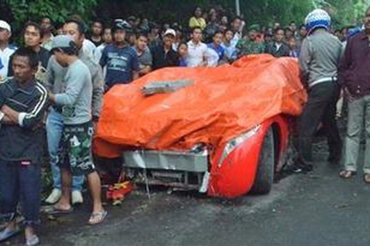Petugas menutupi mobil listrik Tucuxi bernopol D 19 yang rusak berat saat dikemudikan Menteri BUMN Dahlan Iskan,  setelah menabrak tebing dan tiang listrik di Dusun Ngerong, Desa dadi, Kecamatan Plaosan, Kabupaten Magetan, Jawa Timur, Sabtu (5/1/2013). Diduga rem mobil listrik yang didesain oleh Danet Suryatama ini mengalami masalah saat menuruni lereng timur Gunung Lawu. SURYA/DONI PRASETYO
