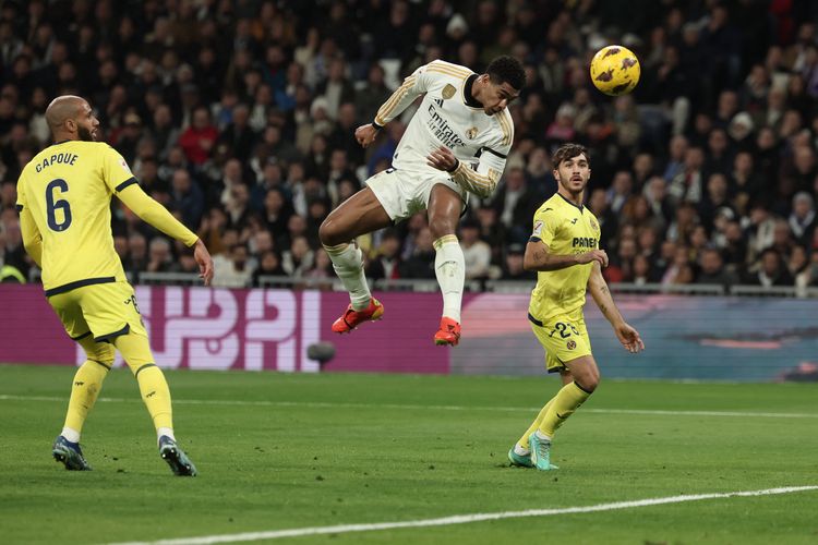 Gelandang Real Madrid Jude Bellingham menyundul bola dan mencetak gol pembuka pada pertandingan sepak bola Lal Liga Spanyol antara Real Madrid vs Villarreal CF di Stadion Santiago Bernabeu di Madrid pada 17 Desember 2023.