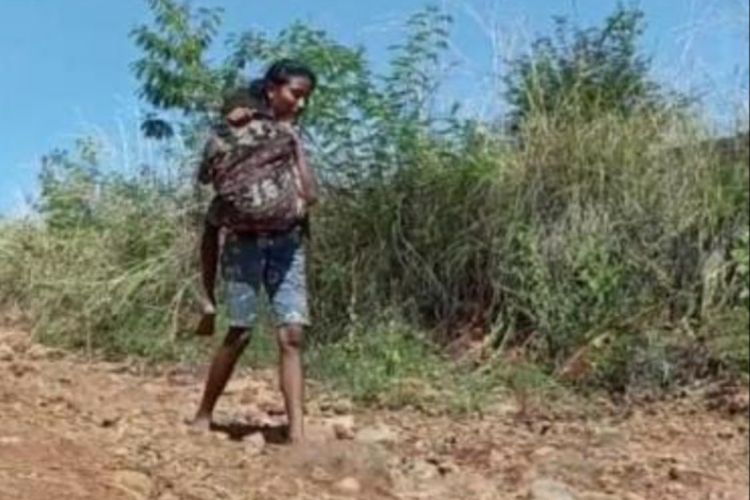Foto: Teresia Sulastri (17) saat menggendong adiknya yang sakit menuju Puskesmas Waigete, Kecamatan Waigete, Kabupaten Sikka, NTT.