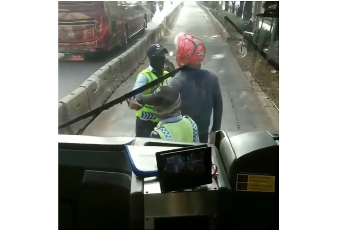 Seorang pengendara motor berdebat dengan petugas Transjakarta. Pengendara motor itu menerobos busway.