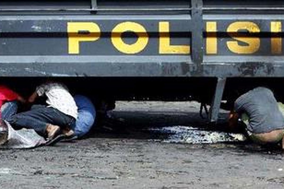 Warga mengais di puing kendaraan bermotor milik aparat yang terbakar pascakerusuhan Koja, Jakarta Utara, Kamis (15/4/2010).