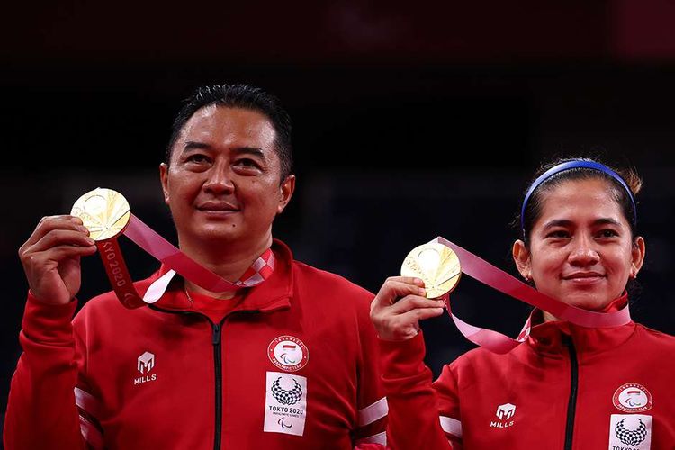 Atlet para-badminton Hary Susanto bersama Leani Ratri Oktila berpose dengan medali emas usai menundukkan atlet para-badminton Perancis Lucas Mazur dan Faustine Noel pada final ganda campuran SL3-SU5 Paralimpiade Tokyo 2020 di Yoyogi National Stadium, Tokyo, Jepang, Minggu (5/9/2021). Ganda campuran Indonesia tersebut meraih medali emas setelah memenangi pertandingan 23-21 dan 21-17.