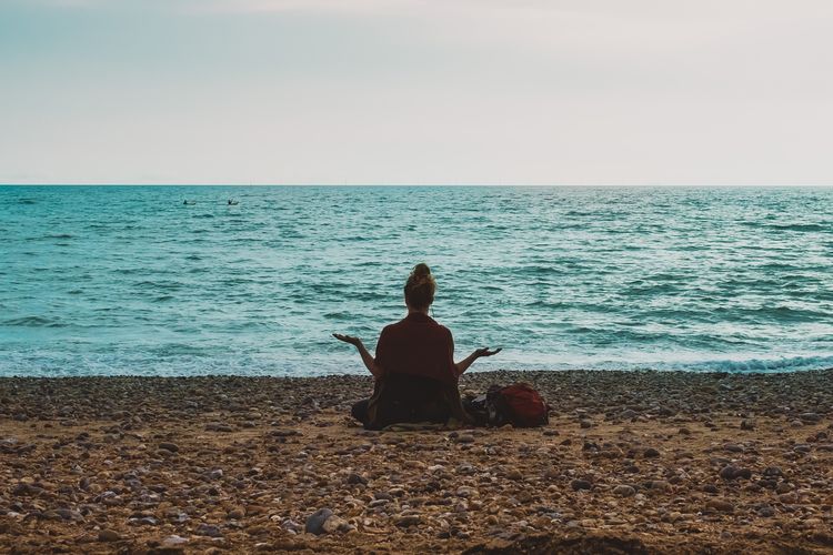 Ilustrasi meditasi di tepi pantai.