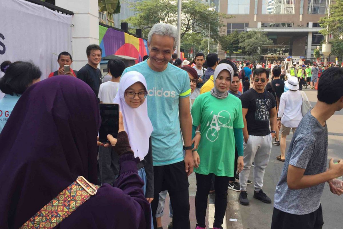 Gubernur terpilih Jawa Tengah Ganjar Pranowo terlihat asyik menonton lomba maraton di Pintu I Gelora Bung Karno, Jakarta Pusat, Sabtu (25/8/2018). Ditemani istrinya, Siti Atiqoh dan anaknya, Muhammad Zinedine Alam Ganjar, ketiganya kompak datang menggunakan setelan pakaian lari.