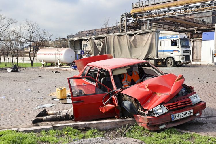 Mayat seorang warga sipil tergeletak di sebelah mobil yang rusak di dekat Pabrik Metalurgi Illich Iron & Steel Works, perusahaan metalurgi terbesar kedua di Ukraina, di daerah yang dikuasai oleh pasukan separatis dukungan Rusia di Mariupol, Ukraina, Sabtu, 16 April 2022.