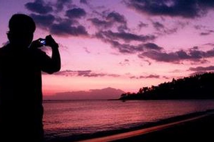 Wisatawan mengabadikan suasana senja di kawasan pantai Senggigi dari The Santosa Villas & Resort, Nusa Tenggara Barat, Kamis (7/7/2011).Objek wisata pantai di pulau Lombok masih menjadi tujuan utama para wisatawan dalam dan luar negeri.