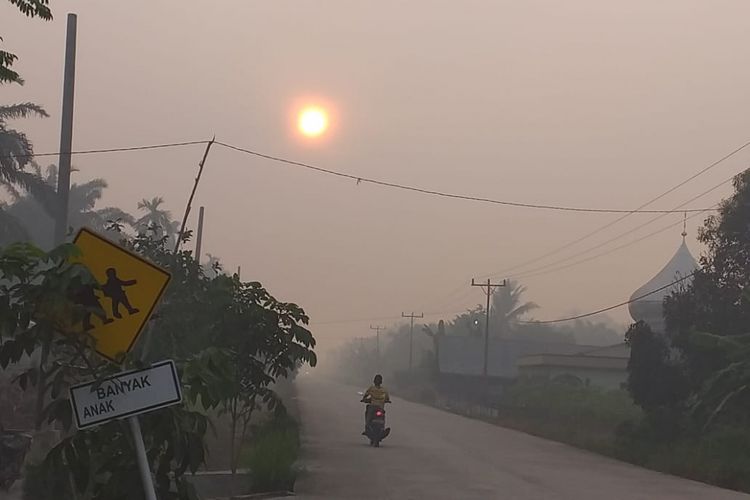 Kondisi kabut asap karhutla yang sangat tebal terlihat di ruas jalan di wilayah Kecamatan Rupat, Kabupaten Bengkalis, Riau, Minggu (24/2/2019).
