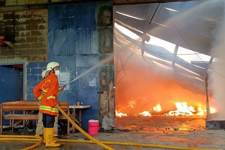 Petugas memadamkan api gudang ekspedisi di Jalan Kapuk Kayu Besar, Kelurahan Kamal Muara, Kecamatan Penjaringan, Jakarta Utara terbaka pada Rabu (6/10/2021).