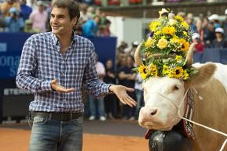 Petenis Swiss, Roger Federer, berdiri di samping Desiree, sapi betina yang jadi hadiah dari panitia Swiss Open, Senin (22/7/2013). 