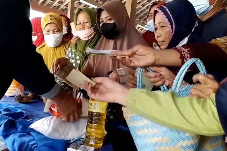 BELI SEMBAKO—Ibu-ibu rumah tangga di Desa Mojorejo, Kecamatan Kebonsari, Kabupaten Madiun, Jawa Timur berebut membeli sembako murah yang dijual Dinas Perdagangan Koperasi dan Usaha Mikro Kabupaten Madiun, Kamis (29/9/2022).