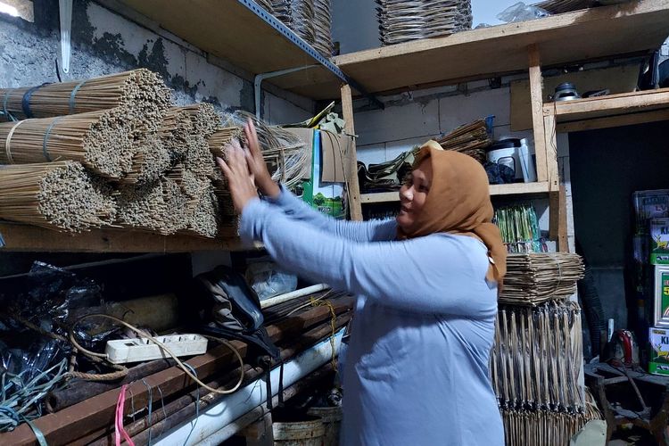 Tinawati atau Titin (37) tengah menata bahan baku layang-layang. Bahan baku ini nantinya diberikan ke perajin untuk kemudian dibuat layang-layang