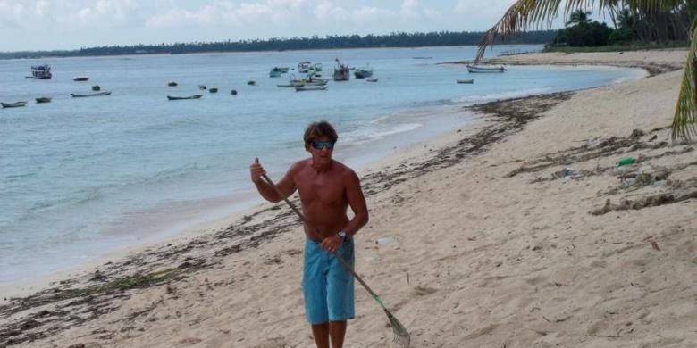 Paul Rainbow (45), turis asal Australia, menyapu pantai Nemberala, Rote Ndao, NTT, Jumat (18/5/2013). Kegiatan ini dilakukan setiap sore hari, saat pantai itu kotor. Penduduk lokal tak peduli terhadap kebersihan pantai itu,
