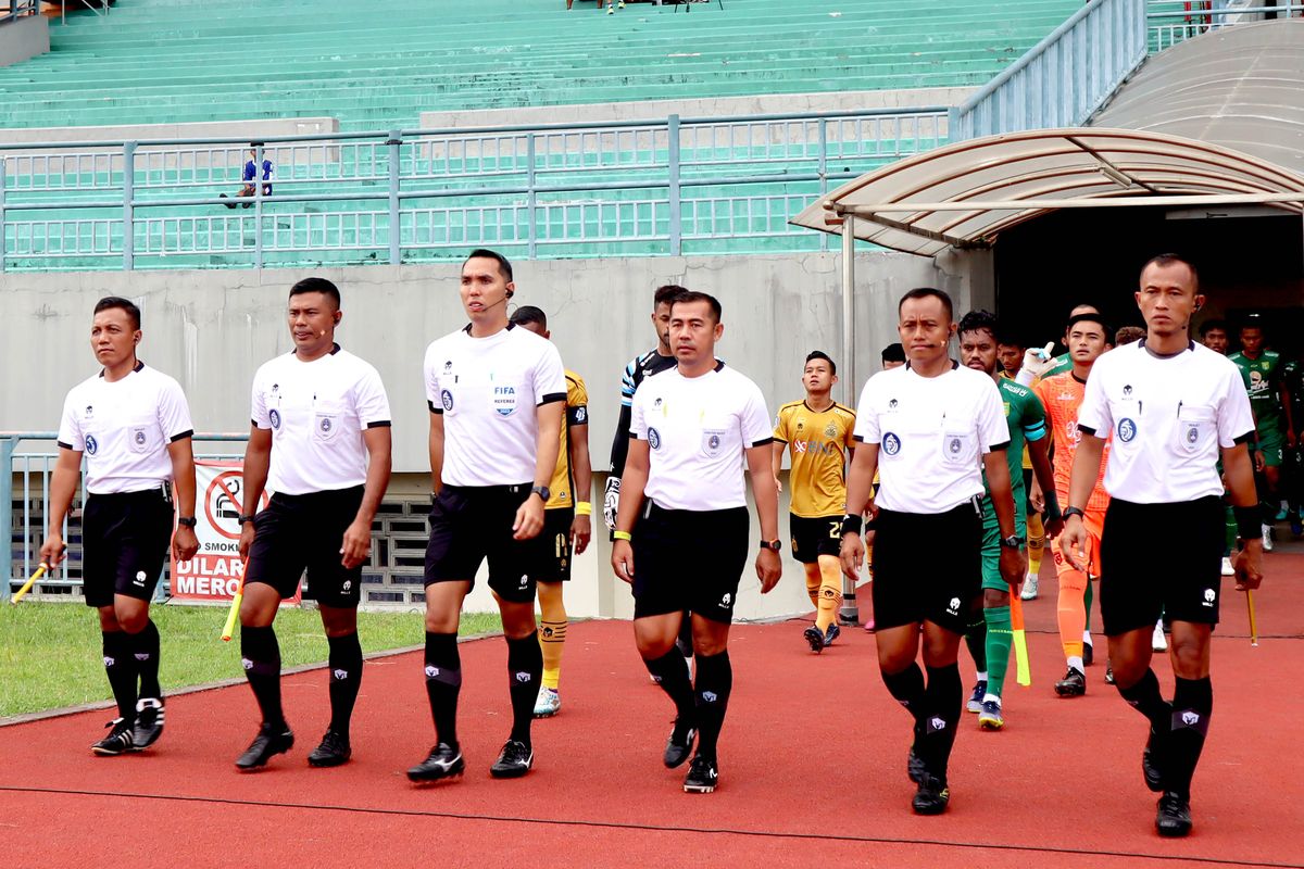 Wasit Fariq Hitaba (dua dari kiri) memimpin pertandingan pekan ke-20 Liga 1 2022-2023 antara Persebaya Surabaya melawan Bhayangkara FC yang berakhir dengan skor 2-1 di Stadion Gelora Joko Samudro Gresik, Senin (23/1/2023) sore.