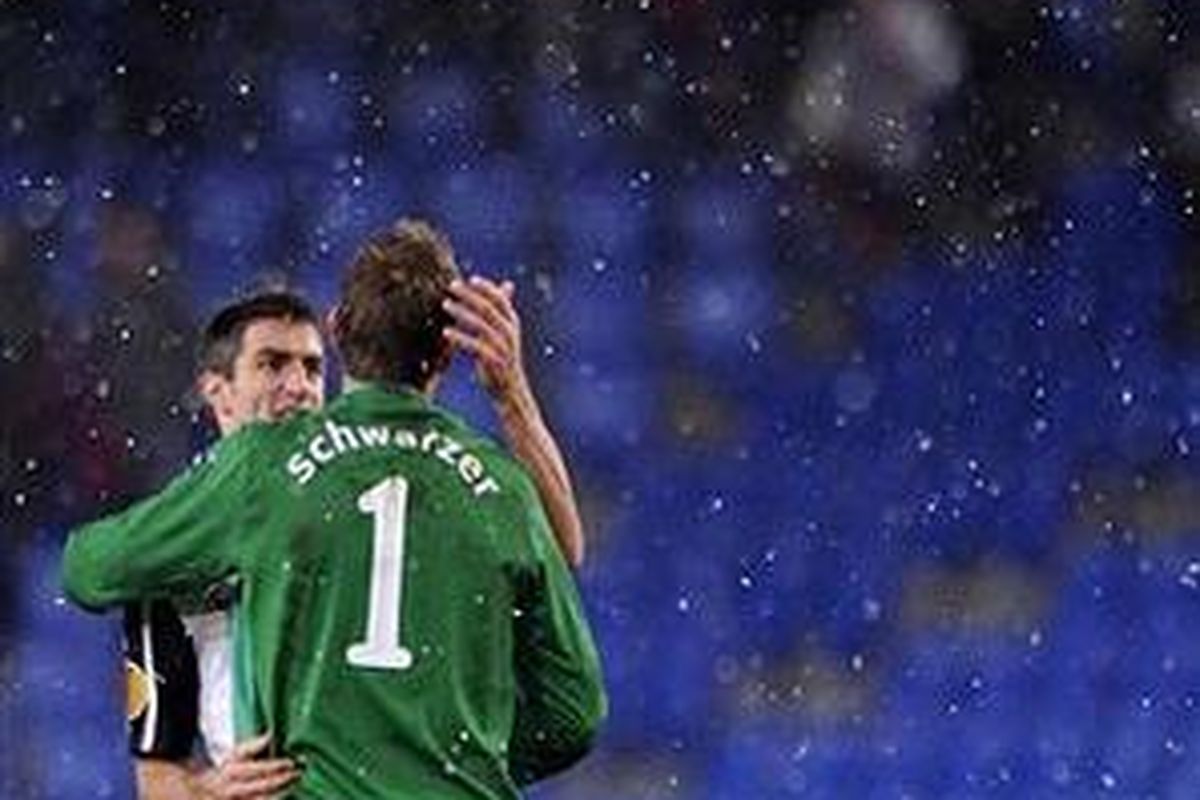 Bek Fulham, Aaron Hughes (kiri), mengucapkan selamat kepada rekannya, kiper Mark Schwarzer, usai timnya menang 3-2 atas FC Basel, dalam lanjutan babak penyisihan Liga Europa, Rabu (16/12/2009).
