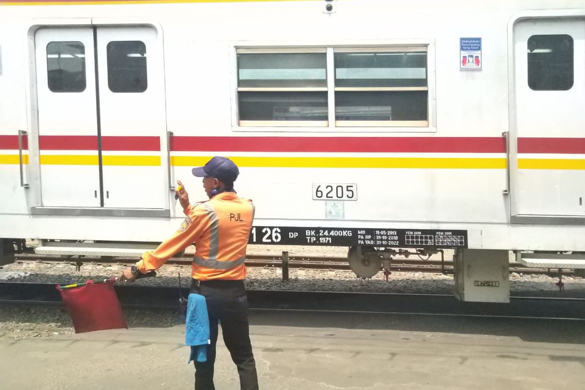 Sulaiman, petugas PJL Stasiun Ancol mmberikan bendera rambu merah yang berarti kereta akan berhenti di Stasiun Ancol pada (04/12/2019) siang hari.