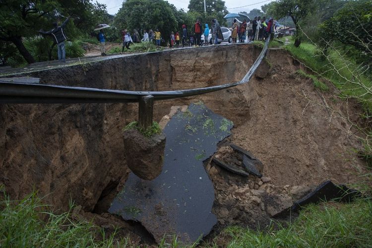 Kondisi umum jalan yang runtuh akibat banjir setelah terjadi hujan lebat menyusul topan Freddy di Blantyre, Malawi, pada Senin (13/3/2023). Pemimpin Malawi pada 13 Maret 2023 mengumumkan keadaan bencana di beberapa distrik selatan termasuk pusat komersial Blantyre setelah topan kuat Freddy kembali membunuh lusinan orang. 