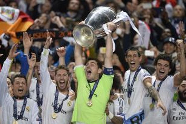 Kapten Real Madrid, Iker Casillas, mengangkat trofi Liga Champions setelah timnya menang 4-1 atas Atletico Madrid, di babak final, di Estadio da Luz, Lisabon, Sabtu (24/5/2014).