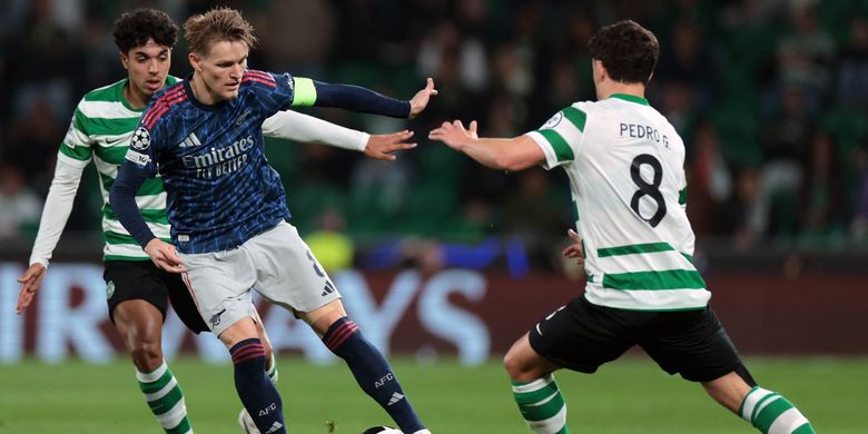 Martin Odegaard dibayangi Pedro Goncalves dan Eduardo Quaresma dalam pertandingan leg pertama perempat final Liga Champions antara Sporting CP vs Arsenal di stadion Jose Alvalade di Lisbon pada 7 April 2026. (Foto oleh PATRICIA DE MELO MOREIRA / AFP)