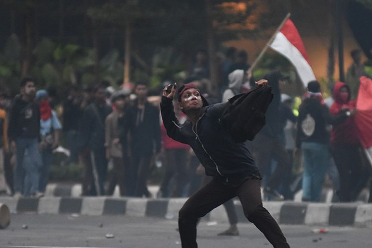 Pelajar melempari polisi dengan batu saat melakukan aksi unjuk rasa di kawasan Pejompongan, Jakarta, Rabu (25/9/2019). Demo yang melibatkan pelajar dari berbagai tingkatan menengah ke atas dan diwarnai kericuhan pada Rabu kemarin masih terkait aksi penolakan UU KPK dan RKUHP yang telah bergulir di sejumlah daerah sejak awal pekan.