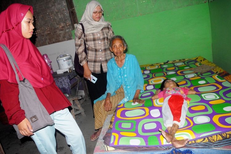 Tim Sekolah Relawan saat menyerahkan bantuan dari pembaca Kompas.com kepada Rosma (10) dan diterima oleh neneknya, Mbah Rani (75) di rumahnya di Desa Nglobar, Kecamatan Purwodadi, Kabupaten Grobogan, Jawa Tengah, Rabu (18/3/2020) sore.