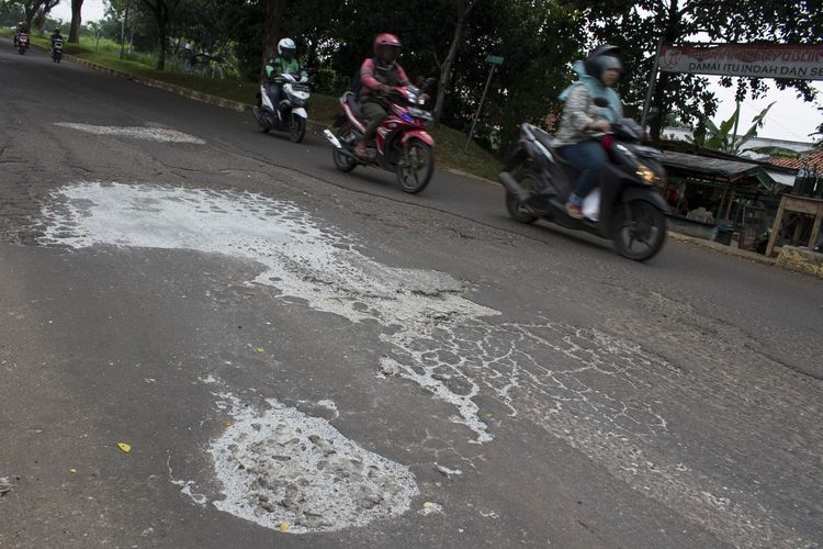 Pengendara melintasi jalan yang berlubang di Grand Depok City (GDC) Grand Depok City, Depok, Jawa Barat, Rabu, (11/12/2019). Beberapa jalan sepanjang GDC masih berlubang dan bergelombang.