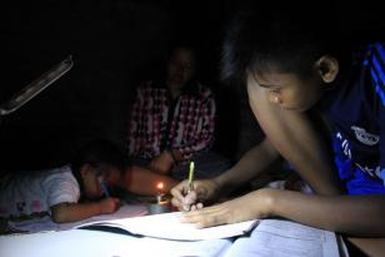 Sari (38) menemani putranya Muhammad Ridho (15) dan keponakannya, Rotiah (5) belajar dalam gelap karena kediamannya tak memiliki aliran listrik. Ironisnya, kediaman Sari hanya berjarak sekitar 100 meter dari Kantor Bupati Cirebon.