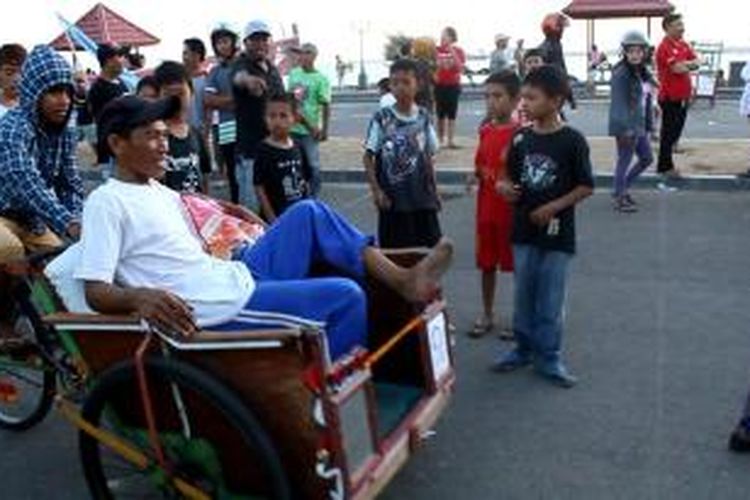 Basri, diantar anak sulungnya, mendekap erat beras 15 kilogram hadiah juara 3 balap becak se-Kota Parepare, Sulawesi Selatan, Minggu (31/8/2014)
