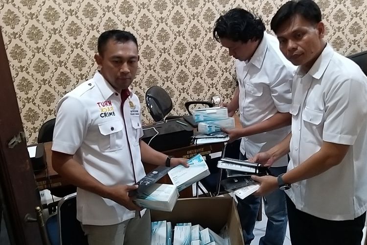 Kasatreskrim Polres Madiun, AKP Logos Bintoro menunjukkan masker yang disita dari EW, penjual bakso asal Desa Geger, Kecamatan Geger, Kabupaten Madiun yang diduga menimbun masker.