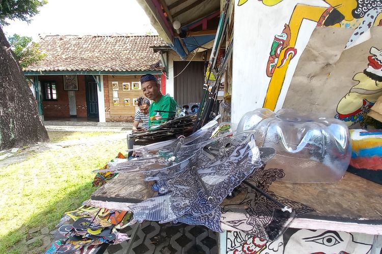 Iskandar saat memotong mengecat Wayang Uwuh yang terbuat dari Plastik, Jumat (13/1/2023)