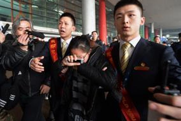 Seorang wanita menangis di Beijing Airport setelah mendengar berita tentang hilangnya pesawat Boeing 777-200 milik Malaysia Airlines, Sabtu (8/3/2014).