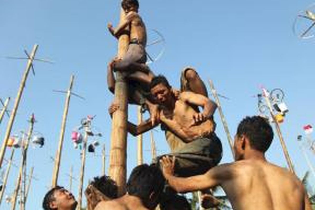 Kerja sama peserta untuk menggapai pucuk batang pinang saat mengikuti lomba panjat pinang dalam rangka HUT Kemerdekaan RI ke-67 di Pantai Festival, Taman Impian Jaya Ancol, Jakarta Utara, Jumat (17/8/2012). Dalam perlombaan itu disiapkan 67 batang pohon pinang dengan aneka macam hadiah. 