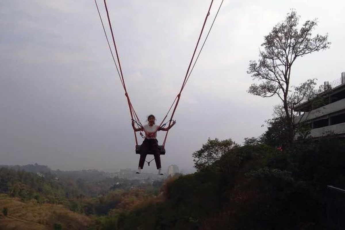 Seorang pengunjung tengah mencoba ayunan raksasa, Giant Swing.