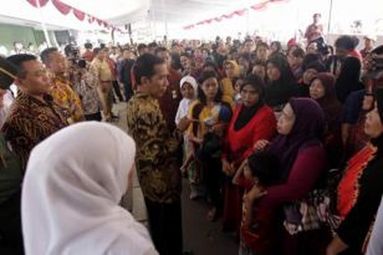 Presiden Joko Widodo berbincang dengan warga usai menyerahkan Kartu Indonesia Sehat (KIS), Kartu Indonesia Pintar (KIP), dan Kartu Keluarga Sejahtera (KKS) di Kantor Pos Kampung Melayu, Jalan Jatinegara Barat, Jakarta Timur, Rabu (13/5/2015).