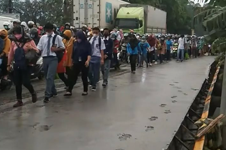 Foto yang menampilkan pejalan kaki melintasi ruas jalan yang baru dicor di Kabupaten Tangerang viral di media sosial.