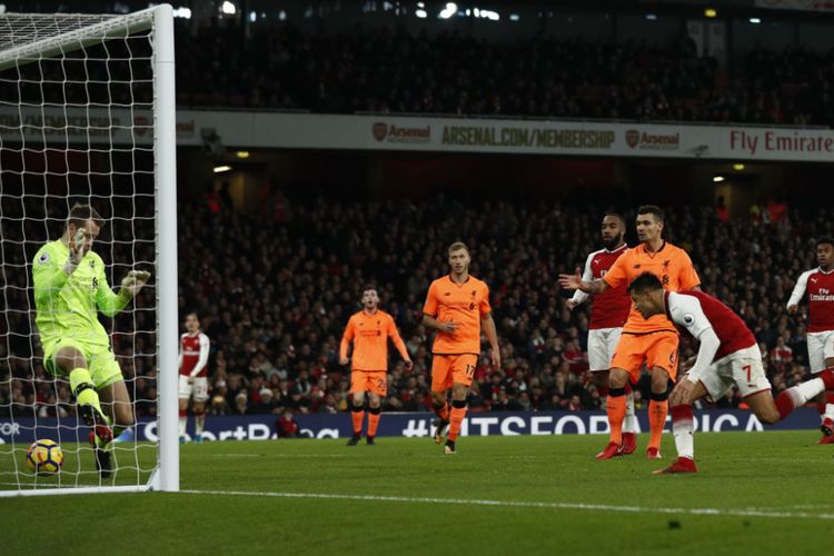 Sundulan penyerang Arsenal, Alexis Sanchez, gagal dibendung kiper Liverpool, Simon Mignolet, pada pertandingan Premier League di Stadion Emirates, Jumat (22/12/2017).