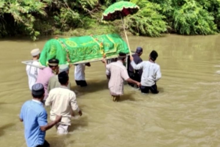 Bidik layar rekaman video amatir warga menggotong keranda jenazah menyeberangi sungai menuju pemakaman di Pekon (desa) Pemerihan, Kabupaten Pesisir Barat beberapa waktu lalu.