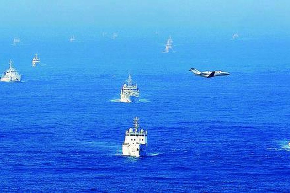 Dua kapal Penjaga Pantai Jepang (paling depan) berlayar di depan armada kapal kesatuan Pengawasan Laut China di dekat wilayah Kepulauan Senkaku atau Diaoyu yang disengketakan dua negara di Laut China Timur, Selasa (18/9) sore. Pesawat kecil yang terbang melintas adalah milik perusahaan media Jepang. Ketegangan kedua negara kembali meningkat sepekan terakhir setelah Pemerintah Jepang memutuskan membeli tiga pulau di gugus kepulauan itu dari pemilik pribadi.