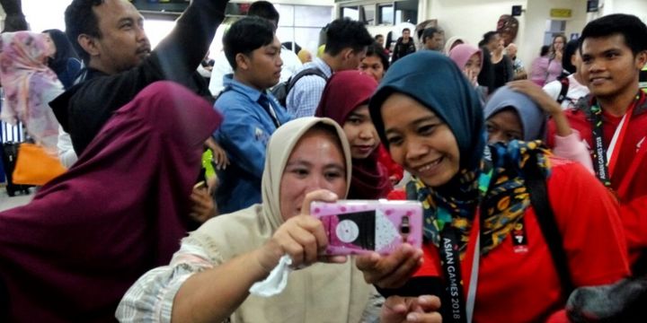 Salah satu atlet panjat tebing Indonesia Puji Lestari saat meladeni selfie warga di bandara Adisutjipto, Yogyakarta, Selasa (28/8/2018)