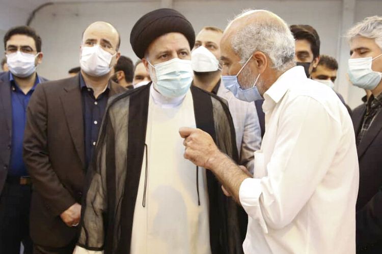 Dalam foto yang dirilis oleh situs resmi kantor Kepresidenan Iran, Presiden Ebrahim Raisi, tengah, mendengarkan seorang pria selama kunjungan tak terduga ke pusat vaksinasi Covid-19 di Teheran, Iran, Selasa, 10 Agustus 2021. (Kantor Kepresidenan Iran melalui AP)