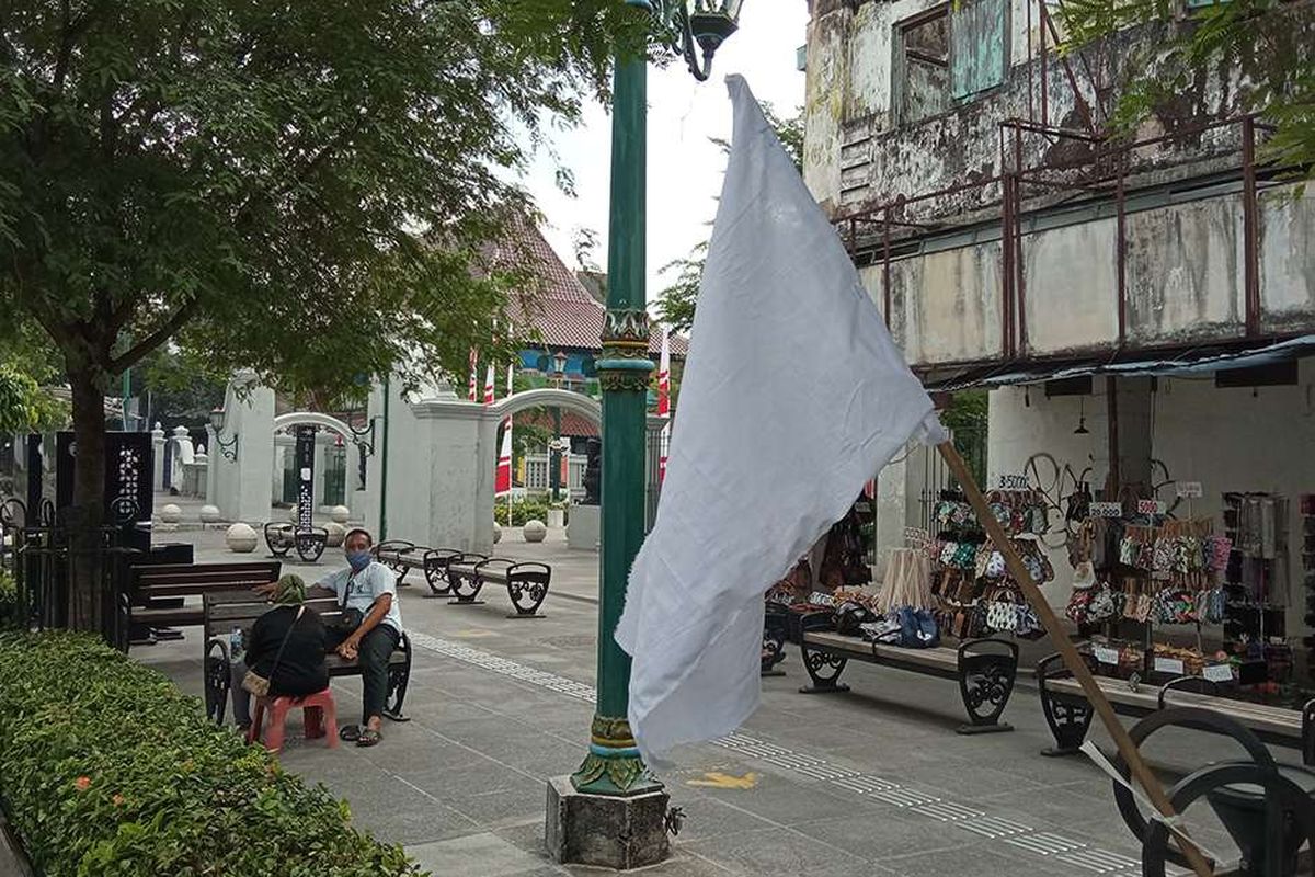 Bendera putih dipasang di sepanjang Jalan Malioboro, DI Yogyakarta, sebagai tanda pedagang kaki lima (PKL) menyerah hadapi pandemi, Jumat (30/7/2021). Para pedagang memasang bendera putih di sepanjang jalan masuk Malioboro hingga di depan kantor Gubernur DI Yogyakarta sebagai simbol ketidakberdayaan dan kesedihan atas kondisi pandemi Covid-19 yang tak kunjung selesai.