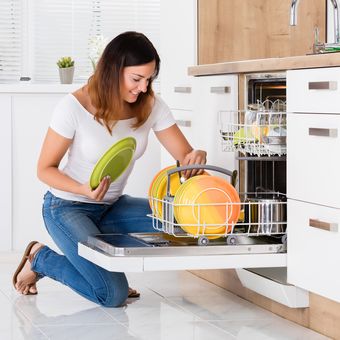 Ilustrasi mengeringkan piring dalam dishwasher atau mesin pencuci piring.