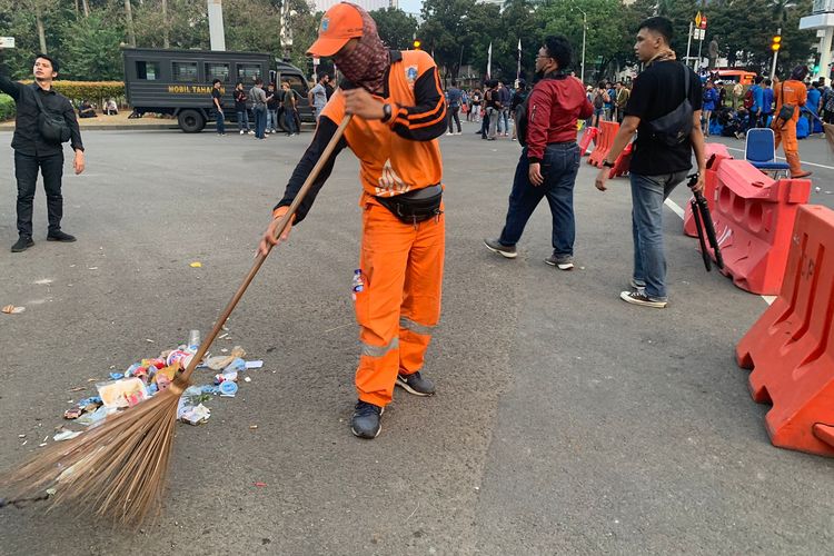 Petugas penanganan prasarana dan sarana umum (PPSU) membersihkan sampah-sampah sisa unjuk rasa di kawasan Patung Kuda, Jakarta Pusat, Kamis (15/9/2022).