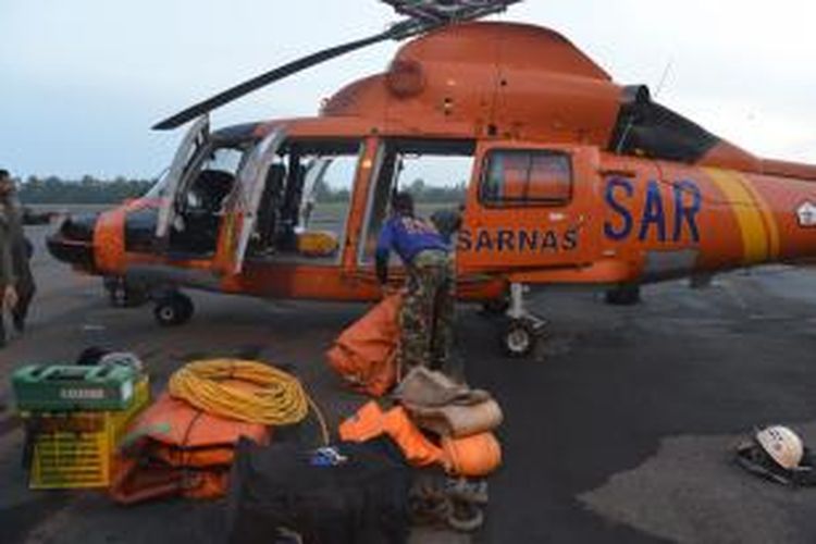 Petugas Basarnas memasukkan lifting bag atau balon udara ke helikopter untuk dibawa ke KRI Banda Aceh di perairan Kalimantan Tengah, Jumat (9/1/2015). Alat tersebut rencananya akan digunakan untuk mengangkat bagian ekor pesawat AirAsia QZ8501.