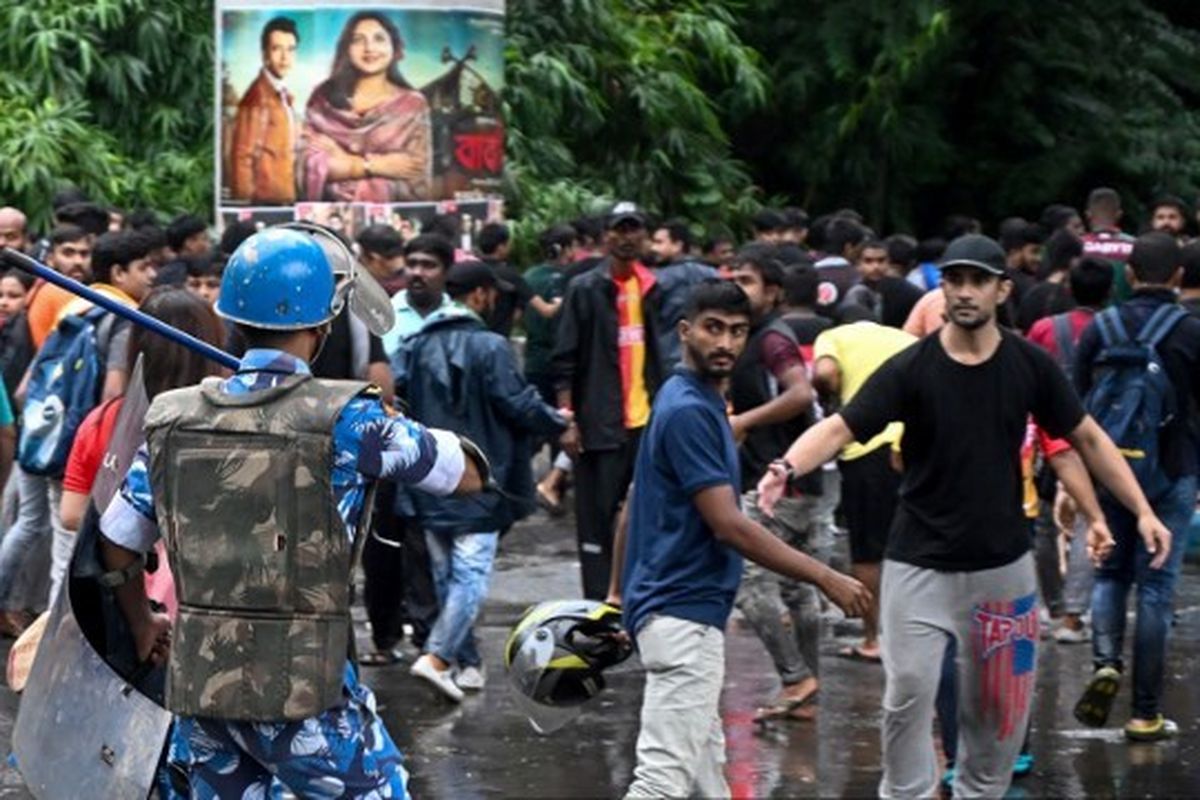 Para pendukung klub sepak bola yang merupakan rival abadi dari kota East Bengal dan Mohun Bagan meneriakkan slogan-slogan ketika polisi menggunakan pentungan untuk menghalangi jalan mereka selama pawai protes untuk mengutuk pemerkosaan dan pembunuhan seorang dokter di negara bagian Benggala Barat, India, di Kolkata, Minggu (18/8/2024).