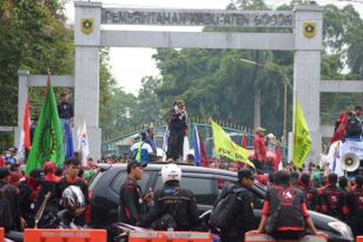 Ribuan buruh di Kabupaten Bogor melakukan aksi unjuk rasa di depan gerbang Gedung Tegar Beriman, Cibinong, Kabupaten Bogor, Kamis (30/10/2014). Dalam aksinya, mereka menuntut kenaikan upah minimum sebesar 30 persen.