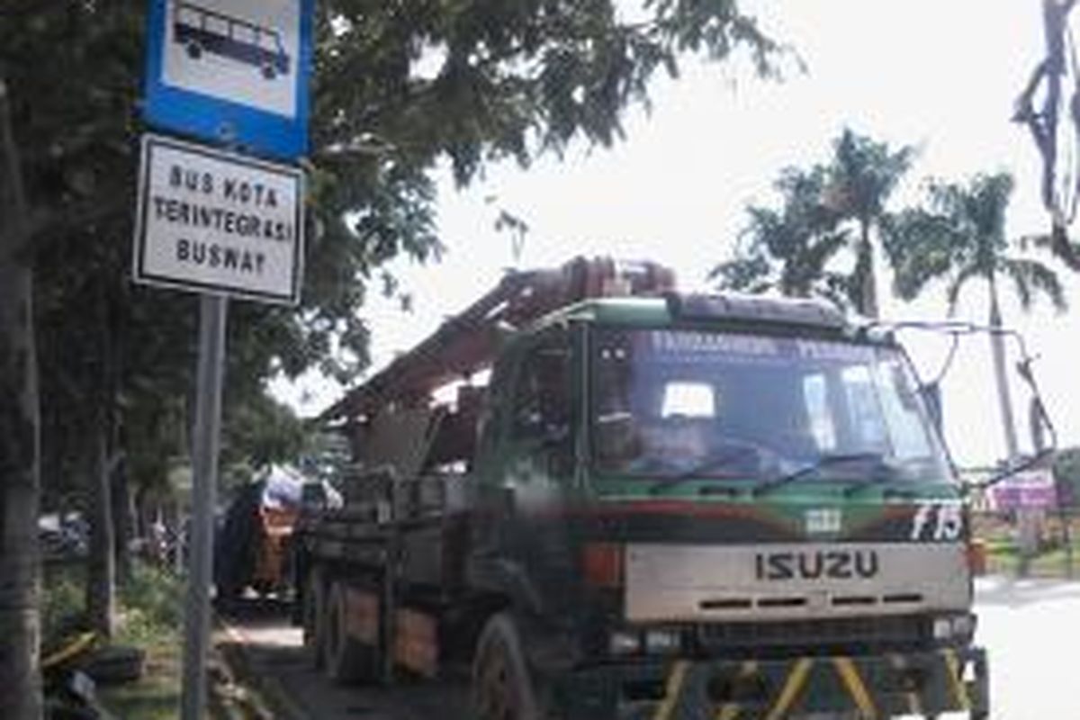 Tempat pemberhentian bus kota terintegrasi busway (BKTB) dimanfaatkan sopir truk di kawasan proyek Pantai Indah Kapuk Mall menjadi tempat parkir, Kamis (13/2/2014).