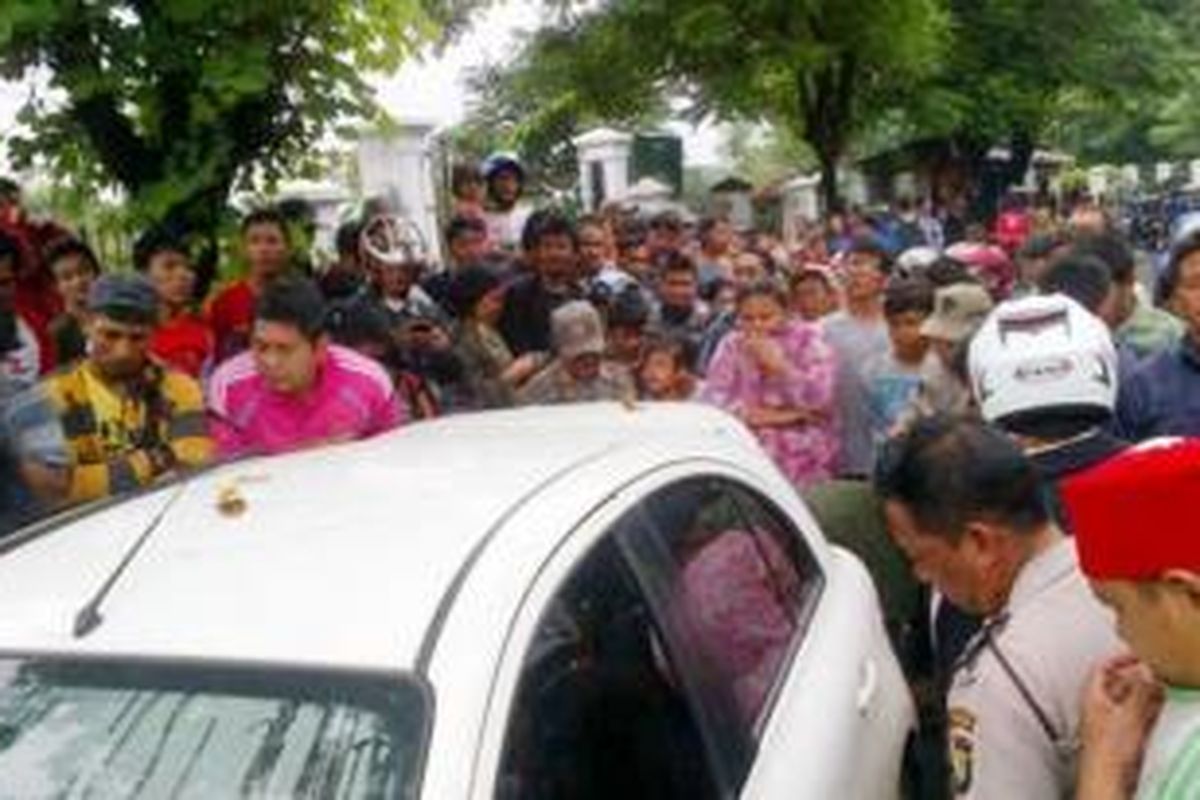 Mobil Nissan March dengan nopol F 1356 KA mengeluarkan bau busuk terparkir di Pondok Kopi, Jakarta Timur, Selasa (28/1/2014).