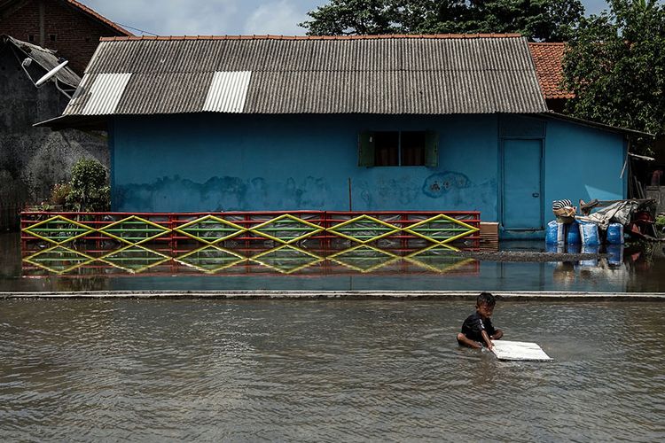 Seorang anak bermain di halaman rumah yang tergenang air rob di Desa Tegalkamulyan, Cilacap Selatan, Cilacap, Jawa Tengah, Rabu (27/5/2020). Gelombang tinggi air laut yang mencapai enam meter di pesisir selatan Jawa Tengah, menyebabkan air rob menggenangi 3.700an rumah, 575 hektar sawah dan 250 hektar tambak udang serta sejumlah fasilitas umum seperti puskesmas, pasar, Tempat Pelelangan Ikan (TPI) dan kantor kelurahan di sejumlah di Kabupaten Cilacap. ANTARA FOTO/Idhad Zakaria/foc.